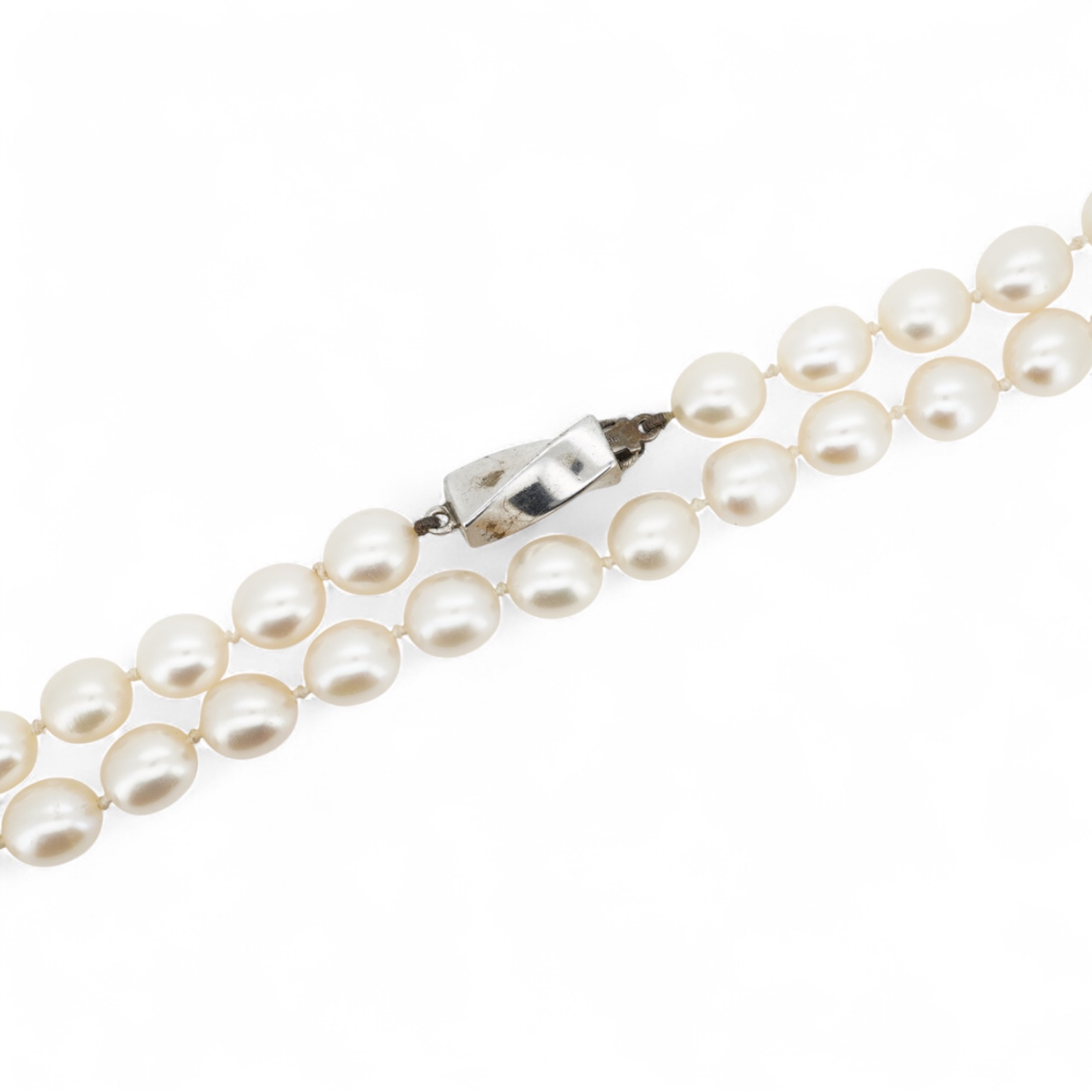 Tiffany & Co., a pair of diamond earrings and a cultured pearl necklace, the earrings of cross design, set with brilliant-cut diamonds totalling approximately 0.30 carats, mounted in platinum, length approximately 0.7cm